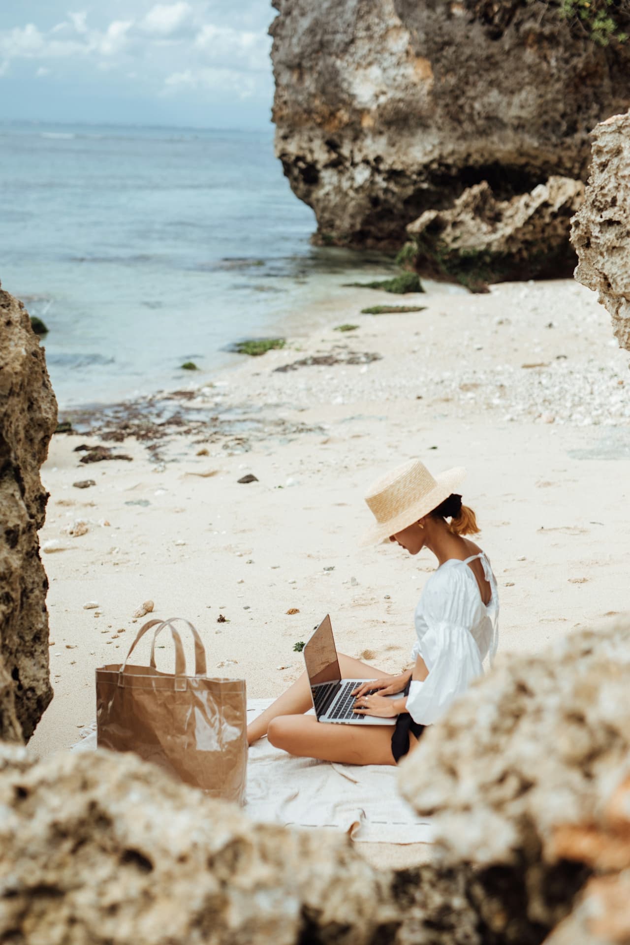 Woman on her laptop on the beach